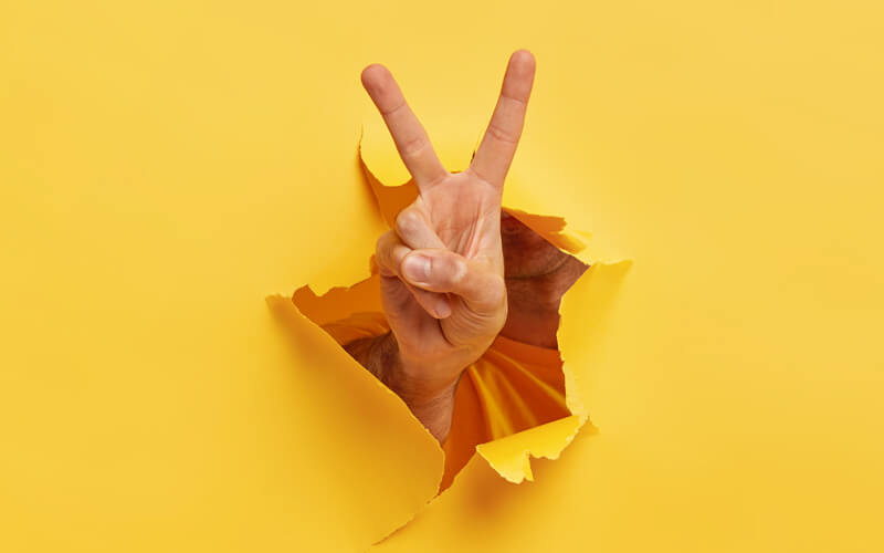 Doigts en V sur fond jaune